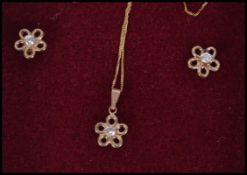 A fine gld necklace with a daisy pendant with matching earings.