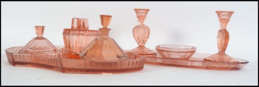 A 1930's Art Deco peach glass dressing table set to include candlesticks, bowls, tray etc.