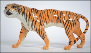 A Beswick ceramic figure of a prowling tiger, printed marks to underside of stomach, 21cms long.