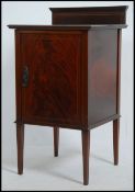 An Edwardian mahogany inlaid pot cupboard - bedside cabinet raised on tapered legs with single