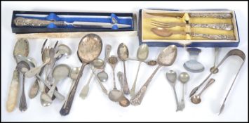 A collection of silver hallmarked and EPNS flatware to include hallmarked sugar tongs, salt spoons,