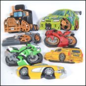 A collection of 7 hand carved and painted wooden wall plaques of vehicles to include American Truck,