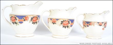 A set of three early 20th century transfer printed graduating jugs each with floral print to the