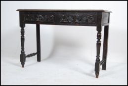 A Victorian Queen Anne revival Jacobean oak writing table desk being raised on cup and cover