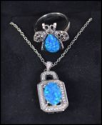 A silver and blue opal and cz adorned ladies dress ring together with a matching pendant necklace.