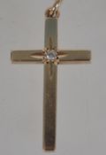 A hallmarked 9ct gold crucifix pendant with inset 2 pts diamond. Measures 3cms long and weighs 2.