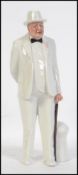 A Royal Doulton figurine of Sir Winston Churchill in white suit and black bow tie,