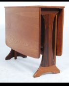 A 1970's G-Plan drop leaf dining table having full length leaves being raised on gate leg action.