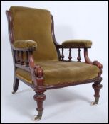 A Victorian mahogany library armchair raised on bulbous turned legs with white ceramic castors,