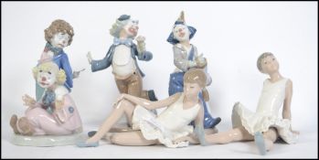 A group of Lladro Nao ceramic figures to include four clown figures together with a pair of ballet