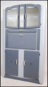 A vintage 1950's retro kitchen dresser cabinet having mottled glass cupboard to top over fall front