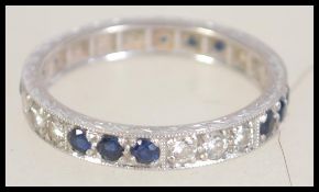 An 18ct white gold sapphire and diamond eternity ring. Unmarked tests 18ct gold. Weight 2.8g.