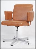 A retro 1970's office swivel desk chair being raised on a polished steel quadruped base with good