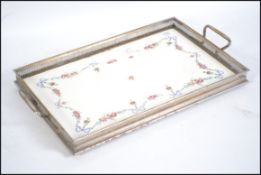 An early 20th century silver plate and ceramic lined salver tray with lattie gallery and twin