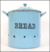 A vintage retro mid century circular lidded bread bin in baby blue with bold lettering to the front