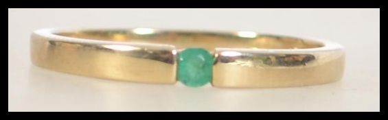 A hallmarked 9ct gold band ring set with a green stone. Size U.5. Weight 2.2g.