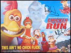 A promotional framed poster print of ' Chicken Run ' being signed by Nik Aardman & Lord.