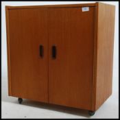 A vintage retro teak Danish inspired record cabinet having twin doors with inset handles opening to
