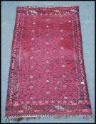 An early 20th century handwoven Bokhara rug with all over geometric design having tassled ends.