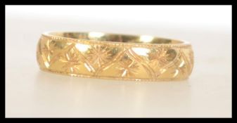 A hallmarked 18ct gold band ring with etched star decoration. Hallmarked for Birmingham. Weight 6.