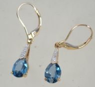 A pair of 9ct gold blue topaz and diamond drop earrings. Weight 1.9g.
