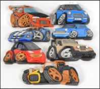 A collection of 7 hand carved and painted wooden wall plaques of vehicles to include dune buggy,