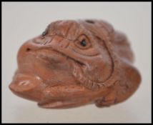 A small carved Japanese wooden Inro in the form of a lucky toad ( see illustrations ).