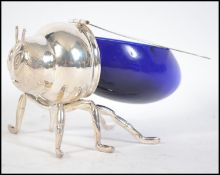 A silver plated and blue glass honey pot in the form of a bee having chased decorated hinged wings