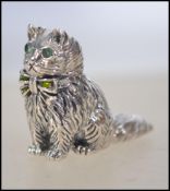 A silver miniature cat set with green emerald eyes ( see illustration ) 3cms high