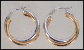 A pair of 9ct white and yellow gold hoop earrings with lever clasp. Weight 1.7g.