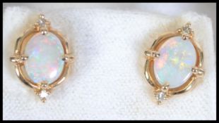 A pair of 14ct gold opal and diamond earrings. Marked 585. Total weight 2.8g.