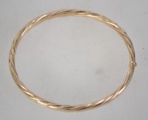 A hallmarked 9ct gold bangle bracelet with hidden clip clasp. Hallmarked Sheffield. Weight 10.