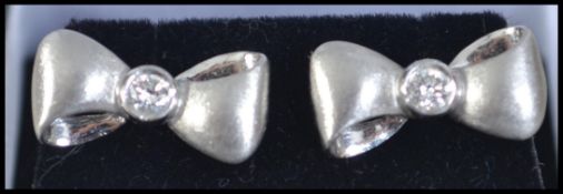 A pair of contemporary white gold and diamond set earrings in the form of bow ties.