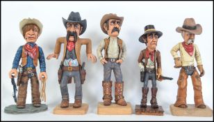 A collection of 6 impressive carved wooden figures of American cowboys to include gunslinger,