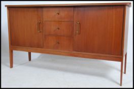 A 1970's retro teak sideboard of Danish influence being raised on tapered legs with cupboards under