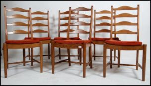 A set of 6 Ercol elm wood rail back dining chairs being raised on turned legs united by stretchers