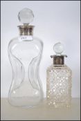 Two silver collared glass decanters the first being a Holmegaard Kluk Kluk Pinched Decanter with a