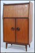 A 1970's retro Danish influence cocktail cabinet / drinks bar having fall front appointed top with