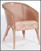 An original Lloyd Loom whicker painted conservatory armchair with cushion seat having label to the