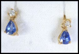 A pair of hallmarked 18ct gold sapphire and diamond drop earrings with tear drop sapphires and