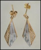 A pair of 9ct white and yellow gold and diamond fan drop earrings. Measures approx 1.5 inch drop.