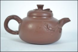 A Chinese yi-xing teapot ( tea pot ) dating to the 20th century being finely potted from terracotta