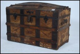 A Victorian wooden and metal bound dome top steamer trunk chest having hinged lid with all over