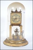 An early 20th century continental brass anniversary clock set to circular plinth with glass dome.