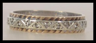 A 9ct white gold and rose gold eternity ring being decorated with a continuous geometric pattern.