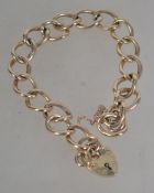A hallmarked 9ct gold chain link bracelet with heart lock clasp and safety chain.