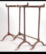 A pair of vintage early 20th century cast iron workmens trestles with swept supports ideal for