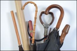 A collection of vintage 20th century ladies parasols and sticks to include a shooting stick.
