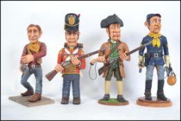 A collection of 4 hand carved and painted wooden figurines to include a cowboy, British soldier,