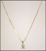 A hallmarked 18ct gold and princess cut diamond pendant necklace. Measures 18 inches.